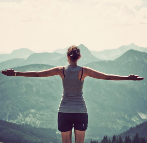 woman out in nature with arms extended