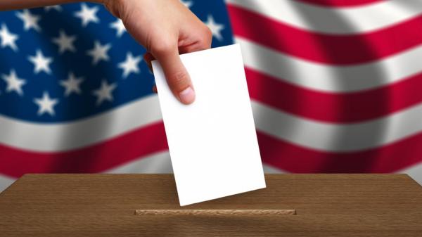 Hand placing ballot in box