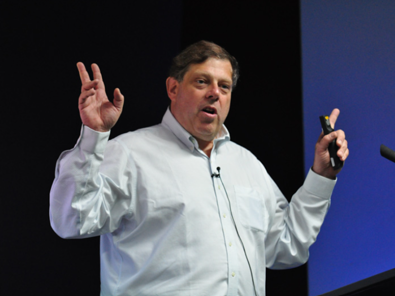 man gesturing in front of a crowd